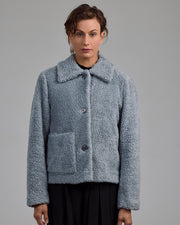 Detail der aufgesetzten Tasche mit Knopf – verspieltes Design-Element der Teddyjacke Eline von Maiken K.