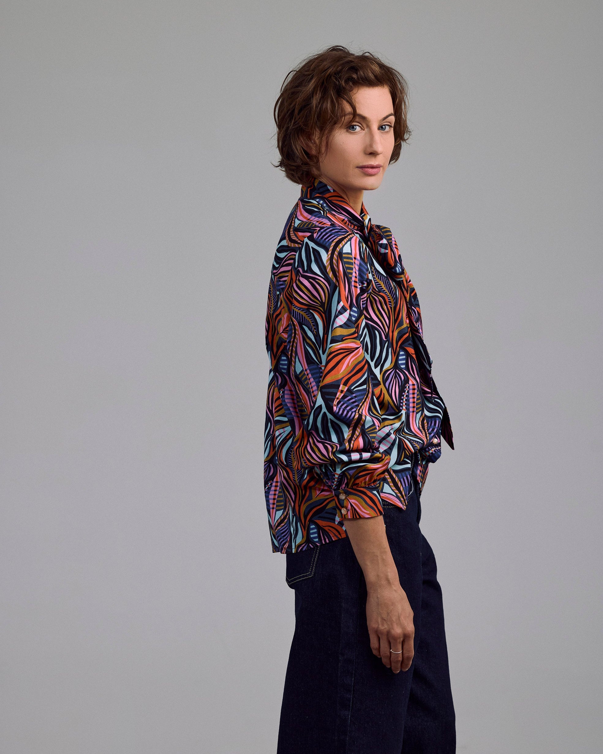 Model trägt die Ovia Bluse von Maiken K. mit farbigem Print – elegant kombiniert