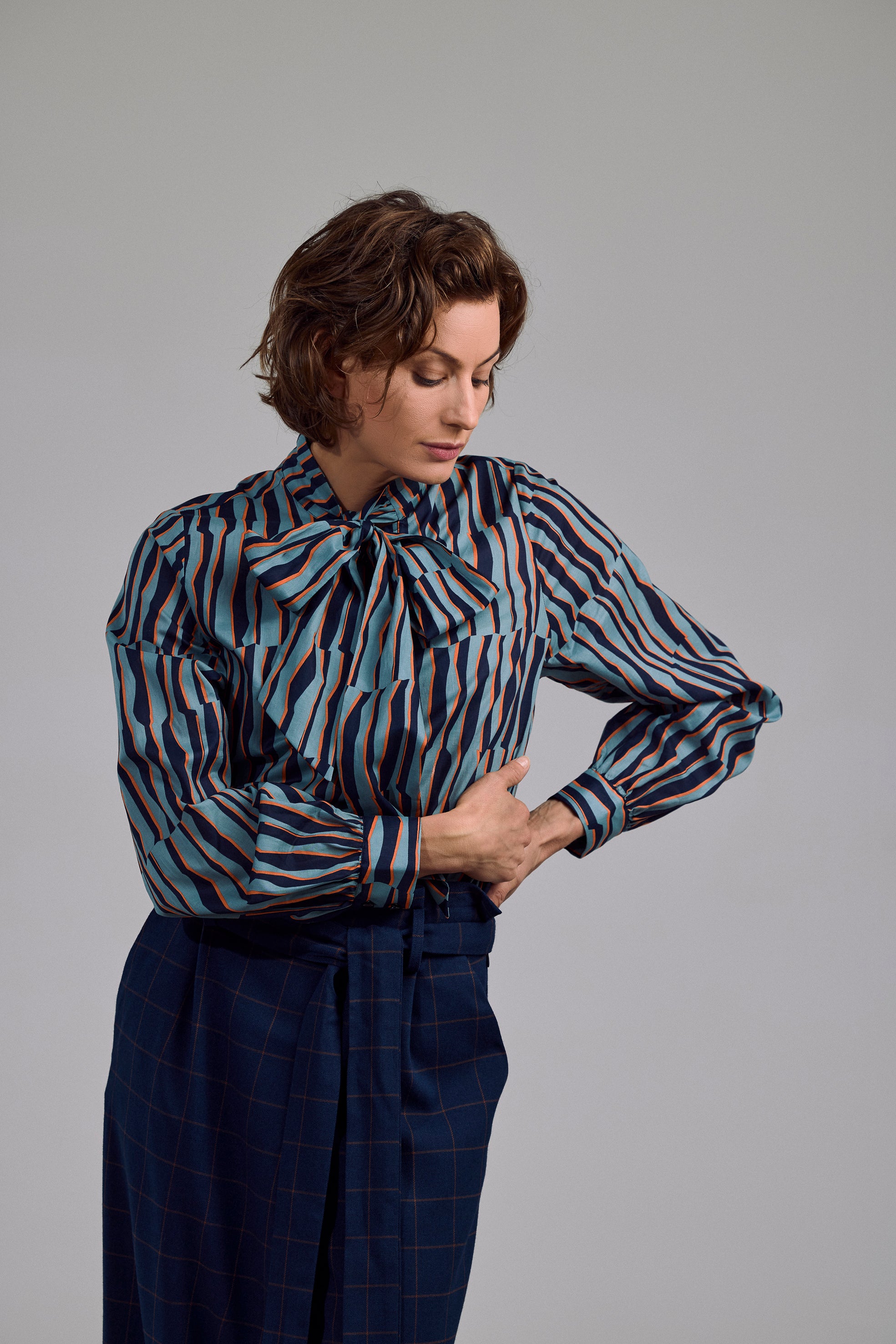 Ovia Bluse von Maiken K. mit geometrischem Muster in Mint, Schwarz & Orange – frontal getragen mit Schleife