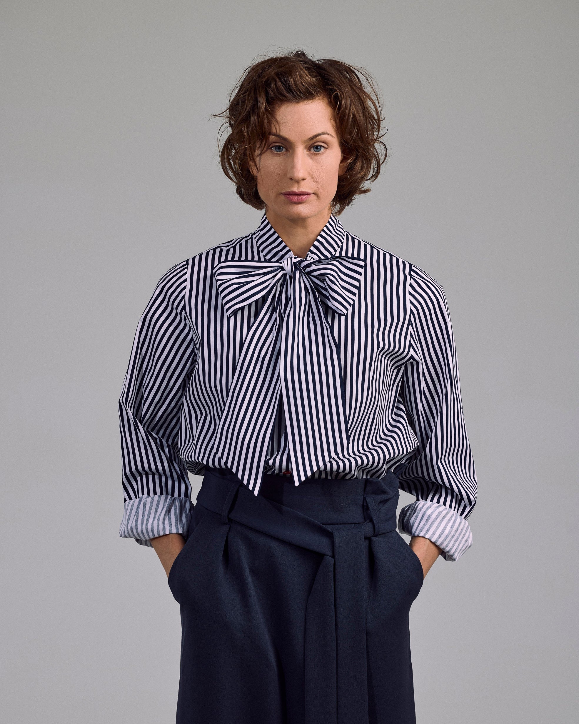 Ovia Bluse von Maiken K. – gestreift in Weiß-Navy, Schleifen-Detail und lockerer Schnitt, frontal getragen