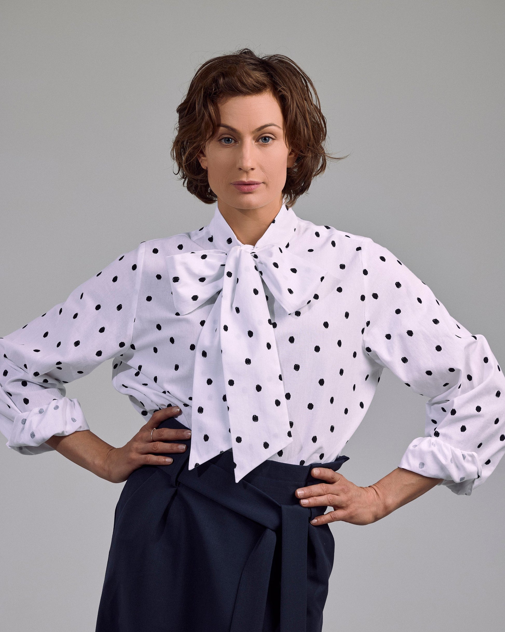 Ovia Bluse von Maiken K. – mit Punkten, in Weiß-Schwarz, Schleifen-Detail und lockerer Schnitt, frontal getragen